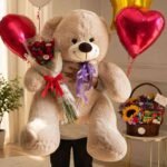 A giant teddy bear holding a rose bouquet alongside a snack hamper, perfect for Gift delivery services in Lahore.