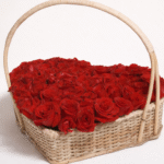 Fresh red roses arranged in a heart-shaped wicker basket, perfect for heart rose basket delivery.