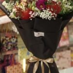 A luxurious fresh flower bouquet in black wrap, perfect for flower delivery Lahore.